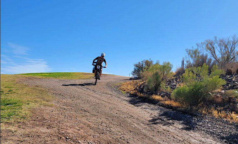A person riding downhill on a mountain bike